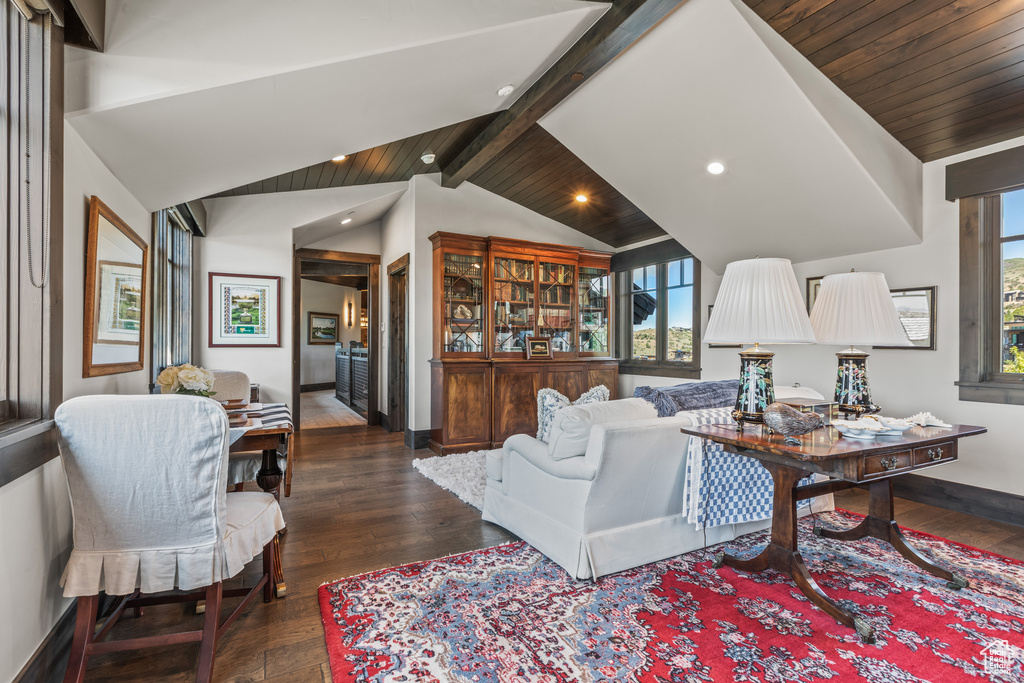 Living room featuring dark hardwood / wood-style flooring and vaulted ceiling with beams