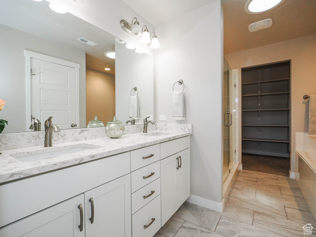 Bathroom featuring tile floors, double sink, separate shower and tub, and oversized vanity