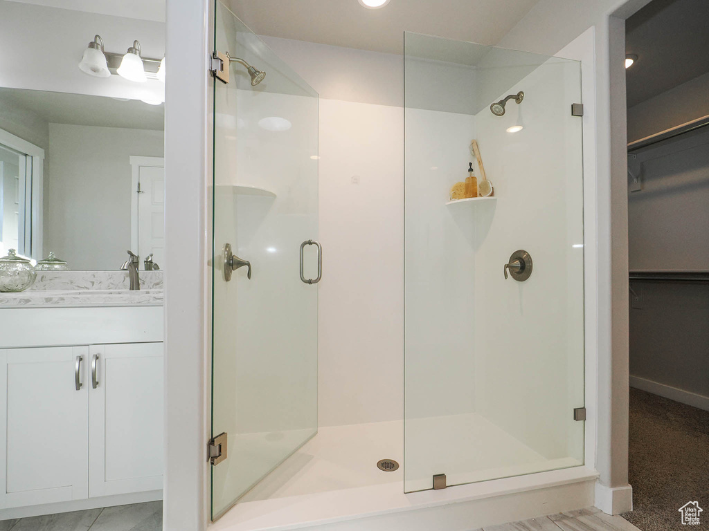 Bathroom featuring a shower with shower door and large vanity