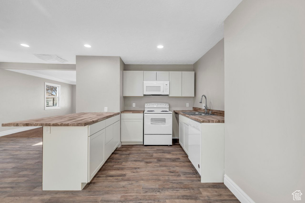 Kitchen with white cabinets, white appliances, sink, and dark wood-type flooring