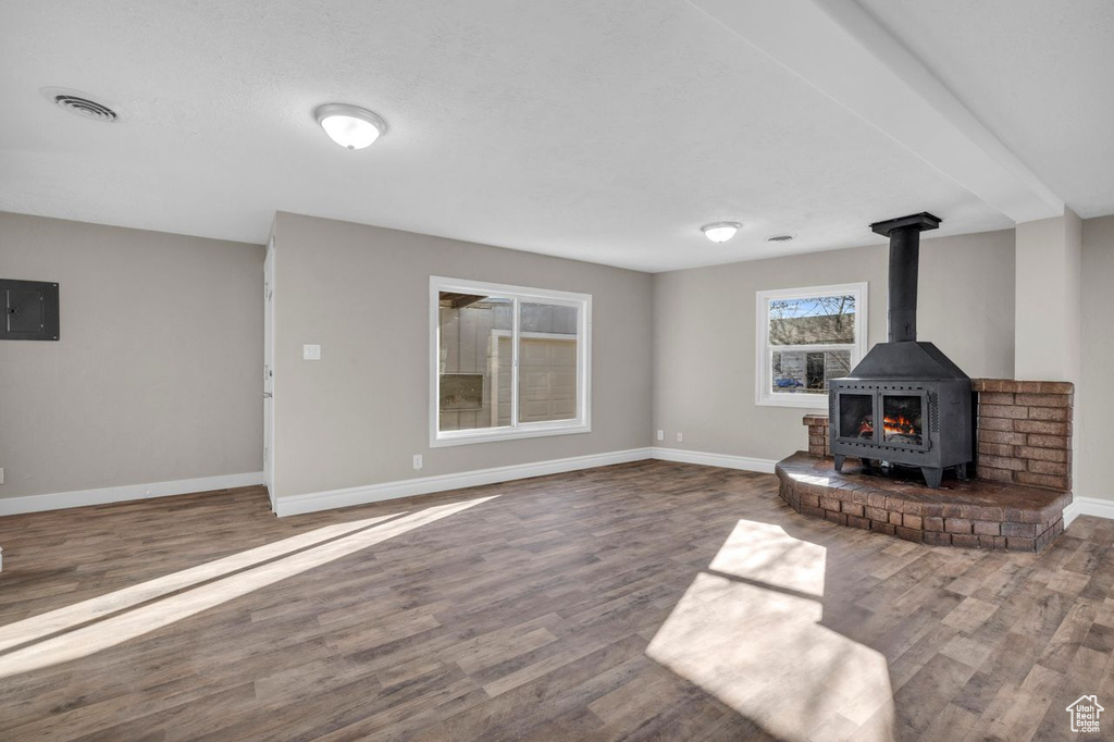 Unfurnished living room with dark hardwood / wood-style floors and a wood stove