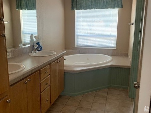Bathroom featuring double sink, a washtub, a wealth of natural light, and oversized vanity