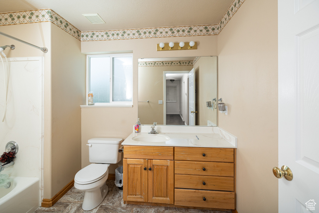 Full bathroom featuring tile flooring, shower / bath combination, oversized vanity, and toilet