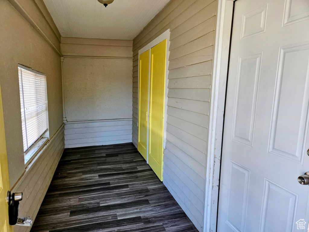 Exterior space with wood walls and dark hardwood / wood-style floors