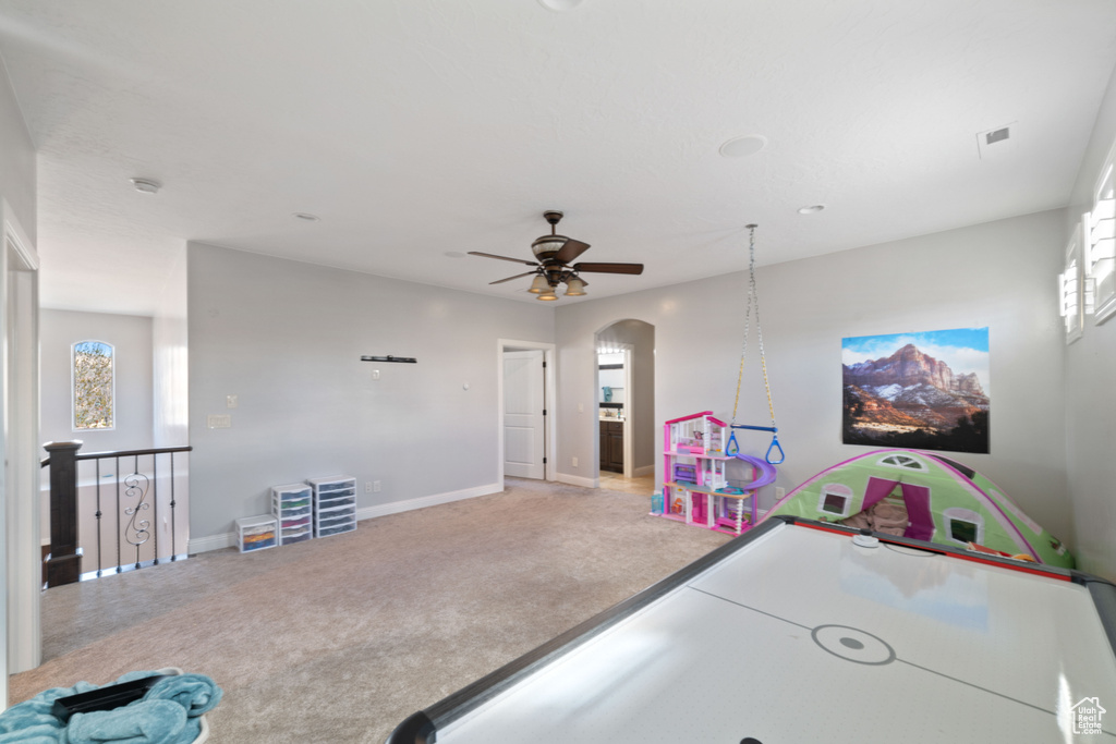 Recreation room featuring light colored carpet and ceiling fan
