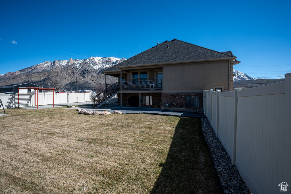 Back of house featuring a yard and a mountain view