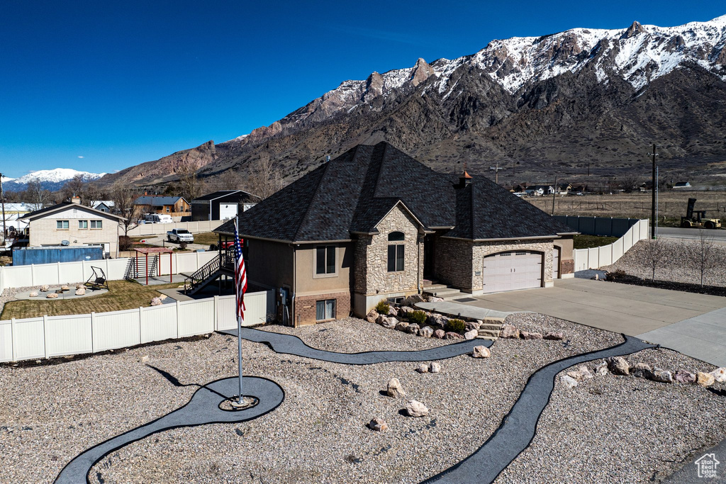 View of front of home with a garage and a mountain view
