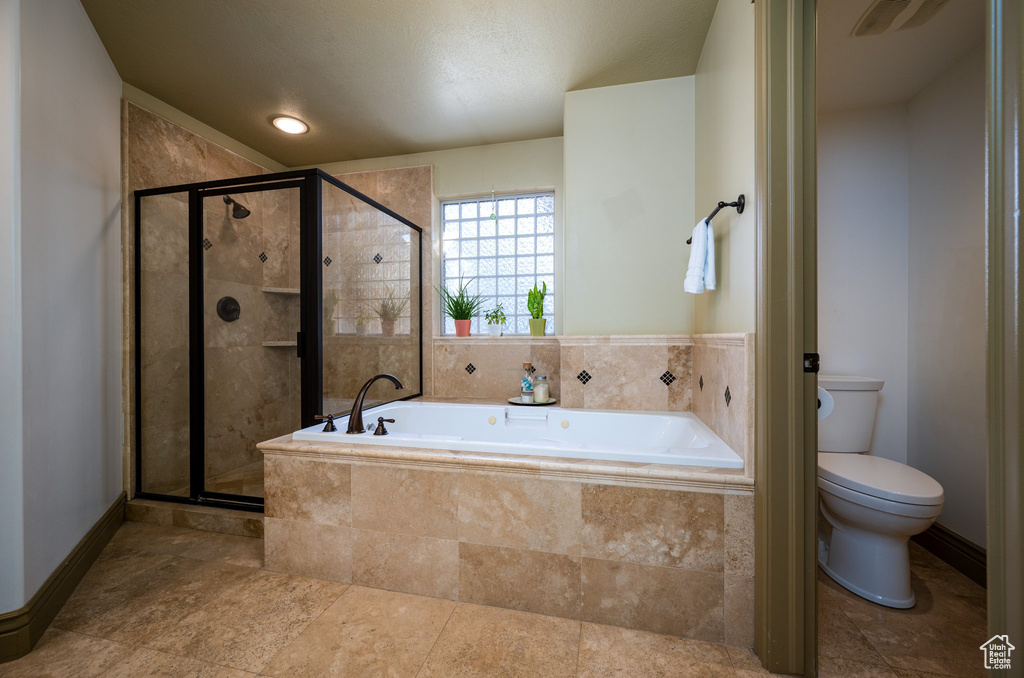 Bathroom with toilet, tile floors, and plus walk in shower