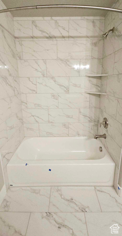 Bathroom with tile flooring and tiled shower / bath