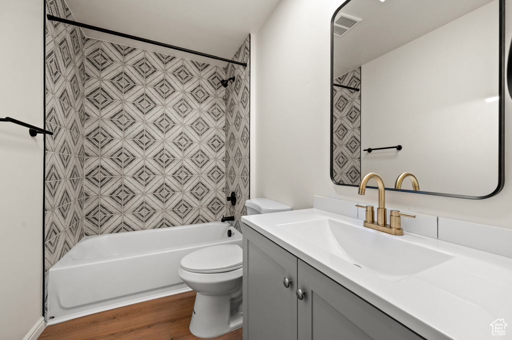 Full bathroom featuring shower / bath combination, vanity, toilet, and wood-type flooring