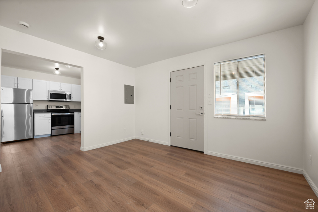 Interior space with dark wood-type flooring, white cabinets, and stainless steel appliances