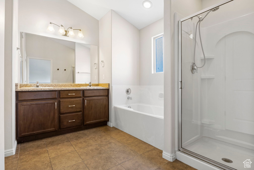 Bathroom featuring tile floors, dual bowl vanity, and plus walk in shower