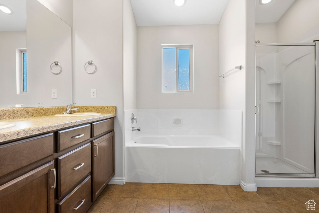 Bathroom featuring double sink vanity, plus walk in shower, and tile flooring
