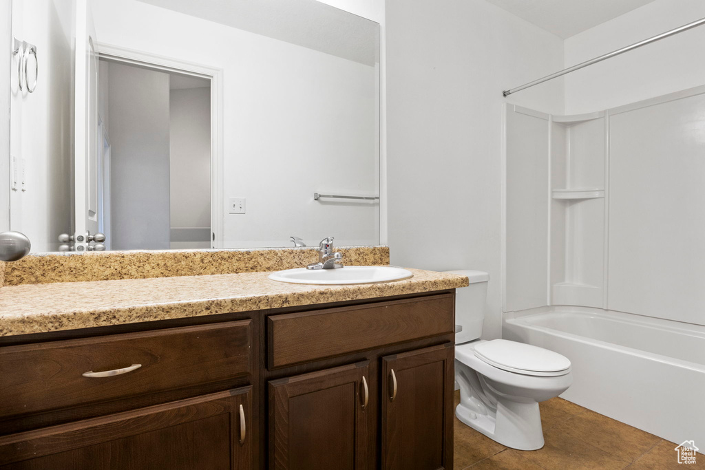 Full bathroom featuring vanity, tile floors, toilet, and shower / washtub combination