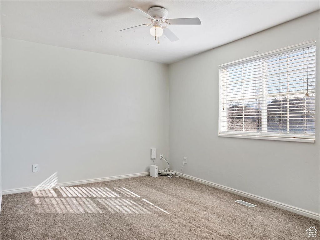 Empty room featuring ceiling fan and carpet