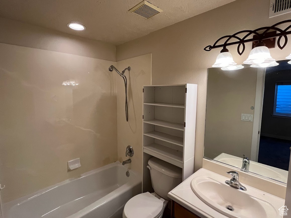 Full bathroom with shower / bath combination, a textured ceiling, toilet, and vanity with extensive cabinet space