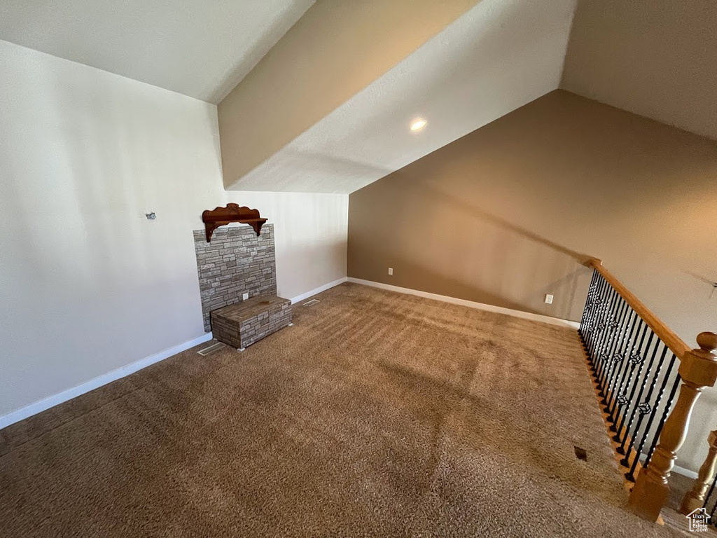 Additional living space with lofted ceiling and dark carpet