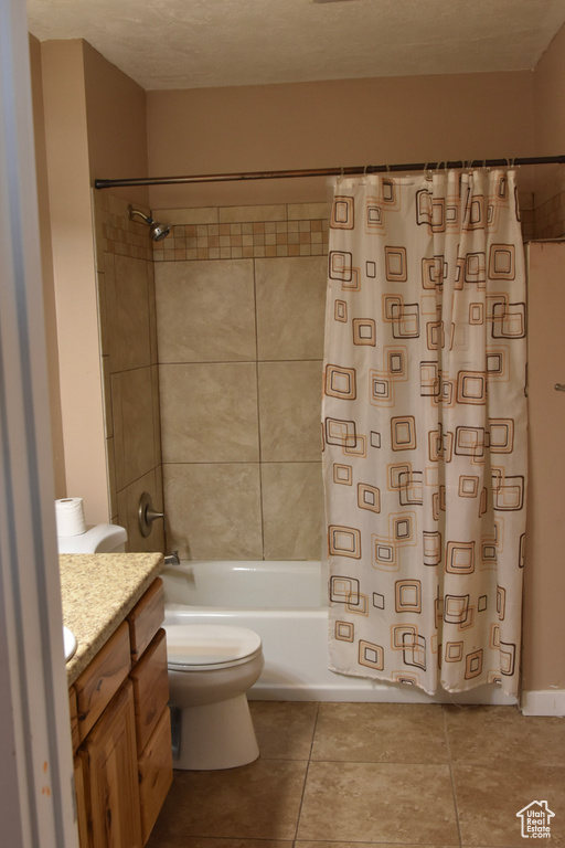 Full bathroom featuring vanity, shower / bath combo, toilet, and tile floors