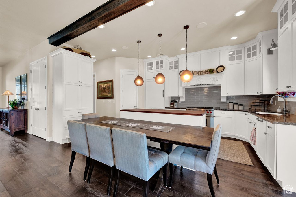 Kitchen with white cabinetry, sink, dark hardwood / wood-style floors, backsplash, and decorative light fixtures
