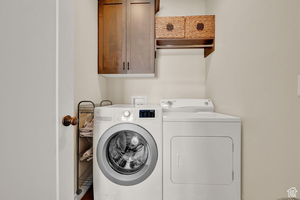 Laundry area featuring cabinets and washing machine and dryer