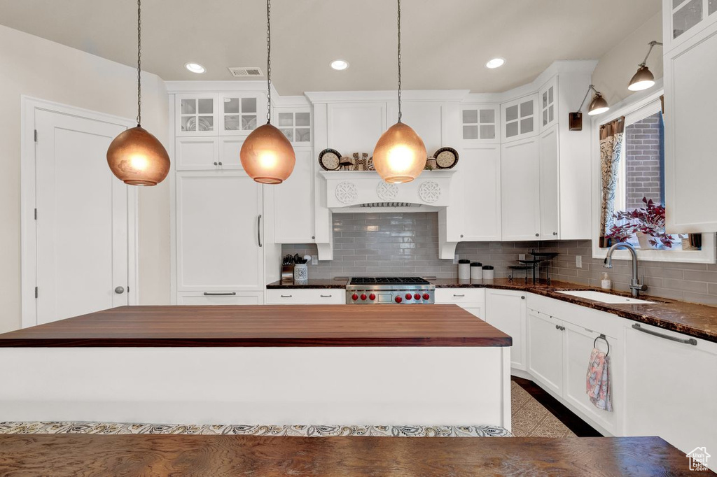 Kitchen with pendant lighting, sink, range, dishwasher, and tasteful backsplash