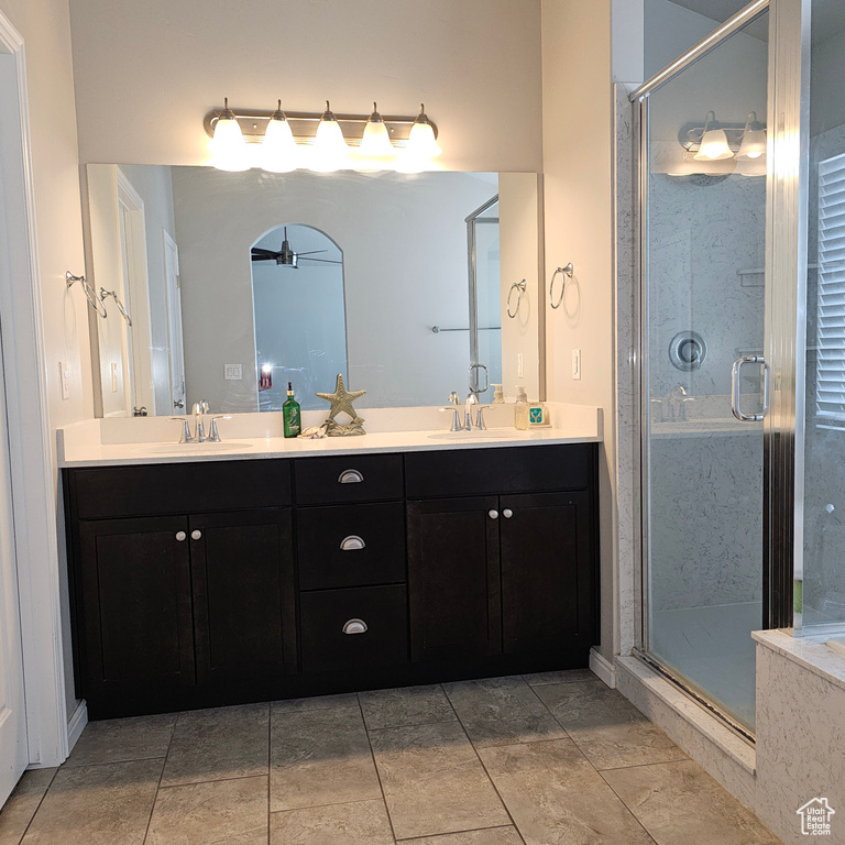 Bathroom featuring double vanity, tile flooring, and walk in shower
