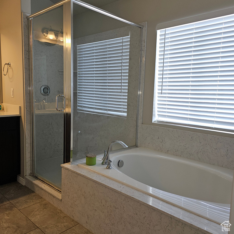 Bathroom featuring tile floors, a healthy amount of sunlight, shower with separate bathtub, and vanity