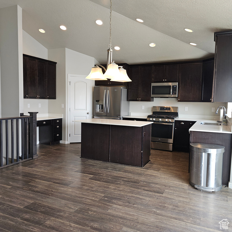 Kitchen featuring dark hardwood / wood-style floors, sink, decorative light fixtures, a kitchen island, and appliances with stainless steel finishes