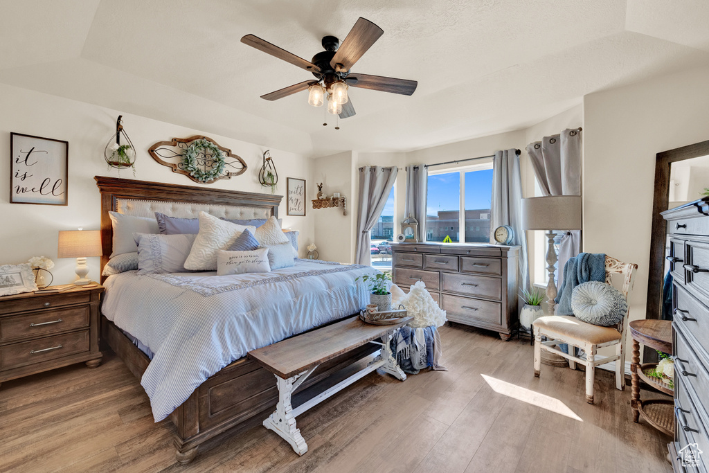 Bedroom featuring a raised ceiling, ceiling fan, and hardwood / wood-style flooring