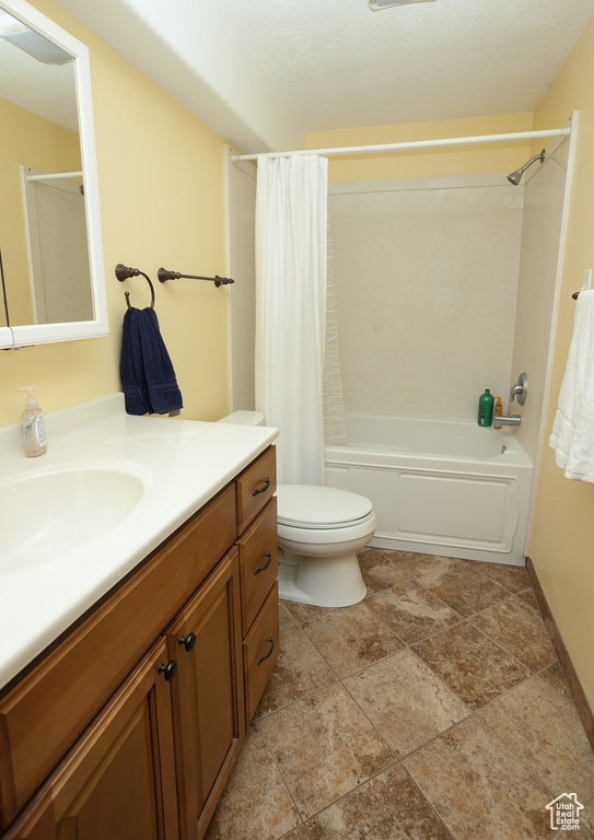 Full bathroom featuring vanity, toilet, shower / bath combo, and tile floors