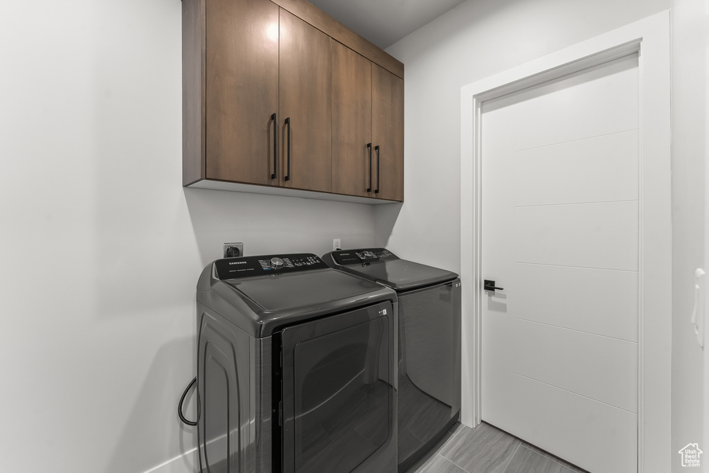 Laundry room with independent washer and dryer, light tile floors, cabinets, and hookup for an electric dryer