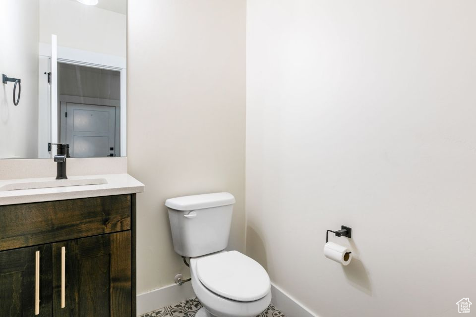 Bathroom featuring vanity, toilet, and tile floors