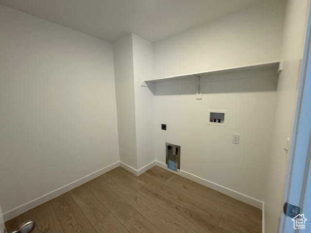 Washroom with hookup for a washing machine and dark hardwood / wood-style floors
