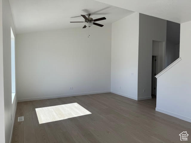 Spare room with dark hardwood / wood-style flooring and ceiling fan