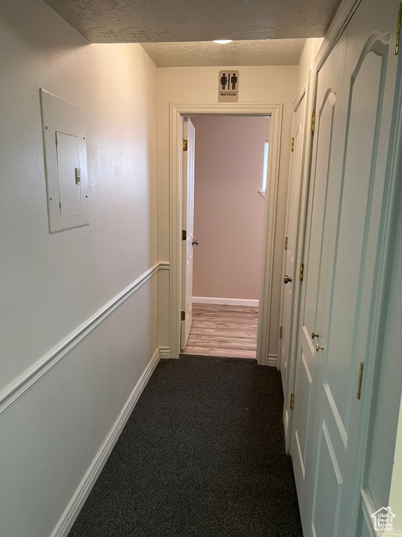 Hallway featuring dark carpet