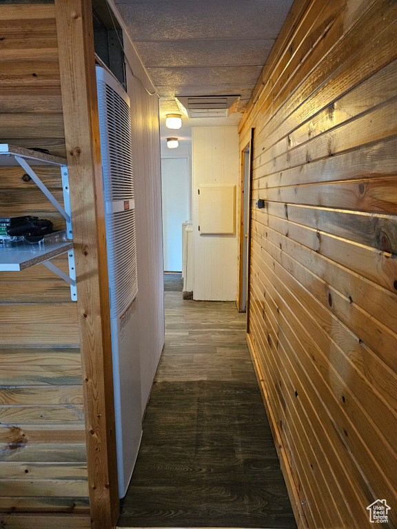 Hall featuring dark wood-type flooring and wooden walls