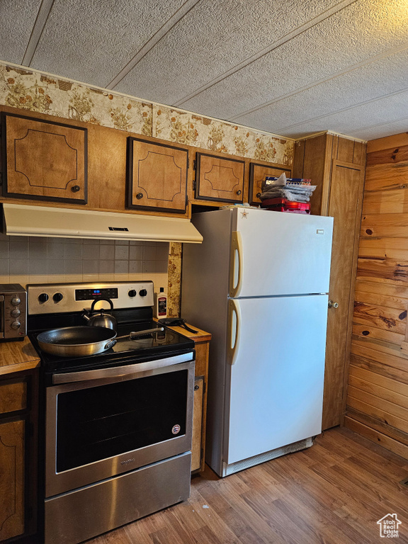 Kitchen with white fridge, electric range, and dark hardwood / wood-style flooring