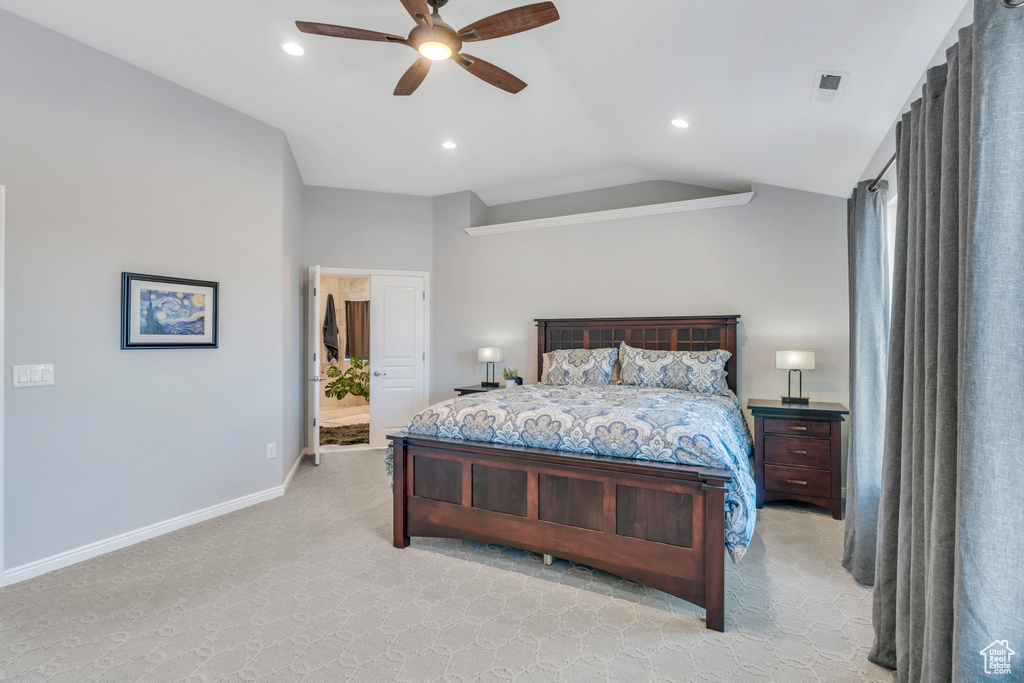 Carpeted bedroom featuring ensuite bathroom, lofted ceiling, and ceiling fan