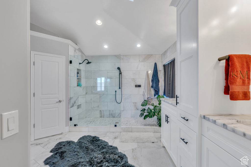 Bathroom featuring tile flooring, lofted ceiling, an enclosed shower, and vanity