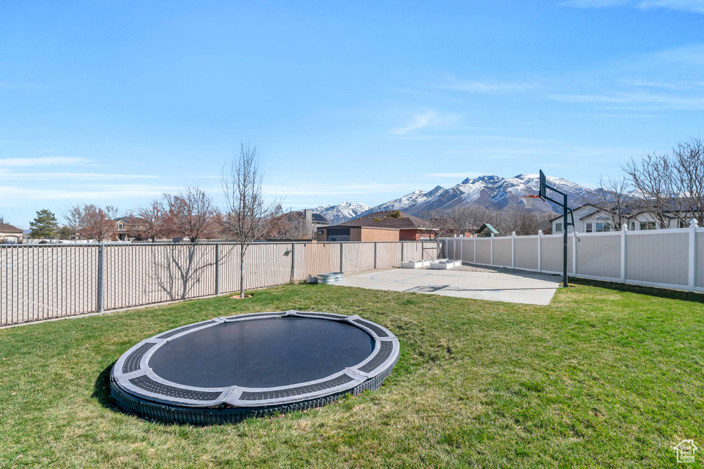 View of yard featuring a patio area, a trampoline, and a mountain view