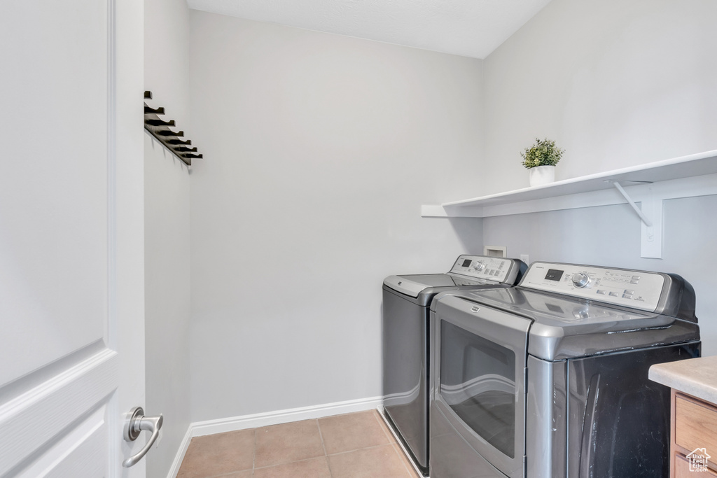 Clothes washing area featuring light tile floors, separate washer and dryer, and washer hookup
