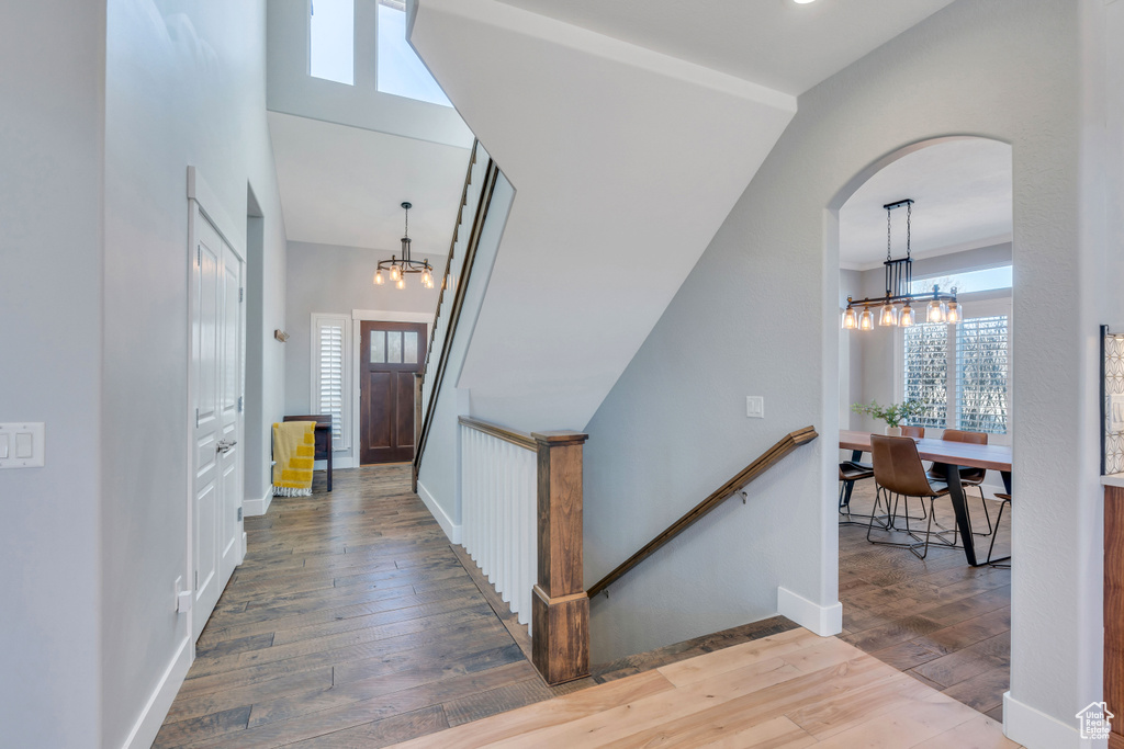 Stairway featuring plenty of natural light, dark hardwood / wood-style floors, a high ceiling, and a chandelier