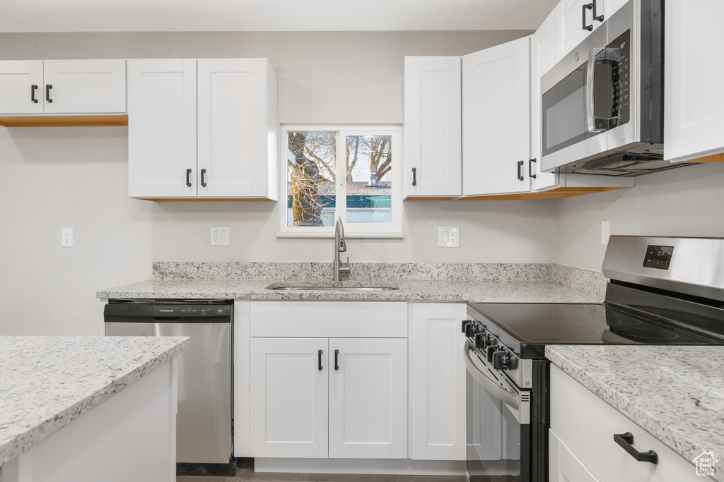 Kitchen featuring sink, white cabinetry, and stainless steel appliances