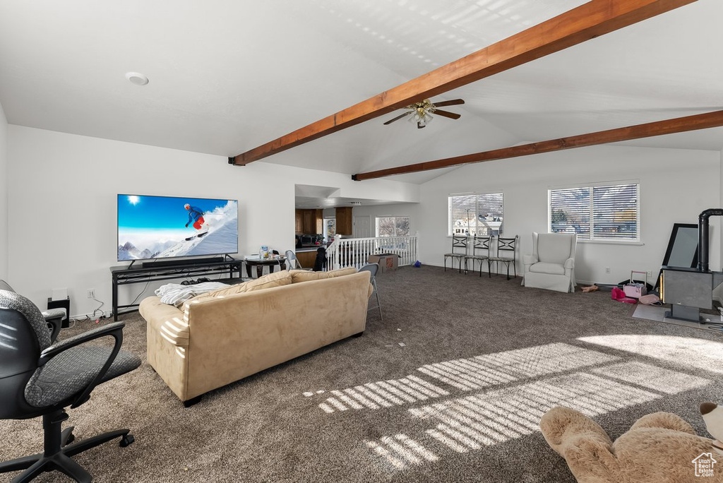 Living room featuring dark colored carpet, ceiling fan, and vaulted ceiling with beams