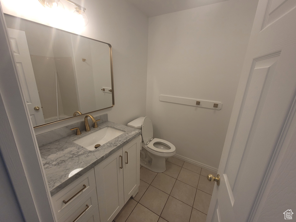 Bathroom featuring tile flooring, large vanity, and toilet