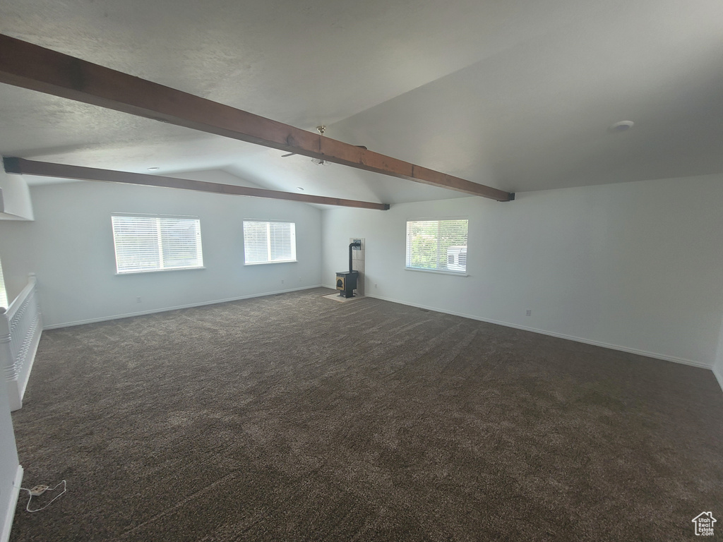 Interior space with vaulted ceiling with beams and carpet flooring