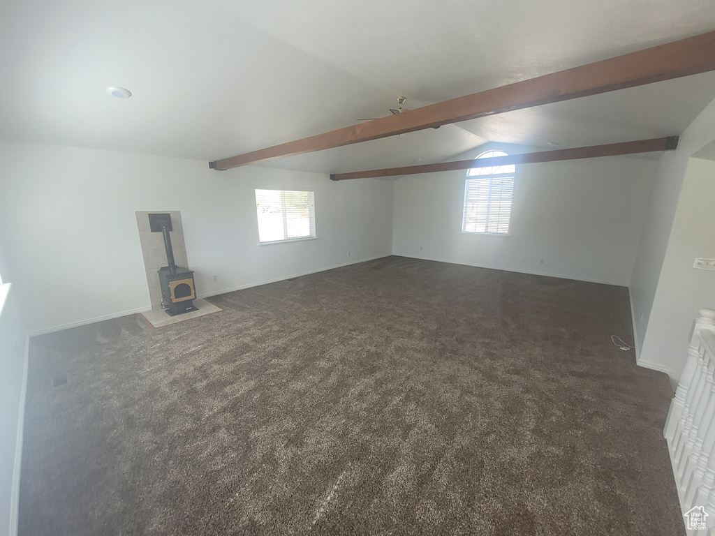 Basement featuring dark carpet and a wood stove