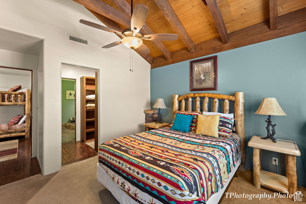 Carpeted bedroom featuring wood ceiling, beam ceiling, and ceiling fan