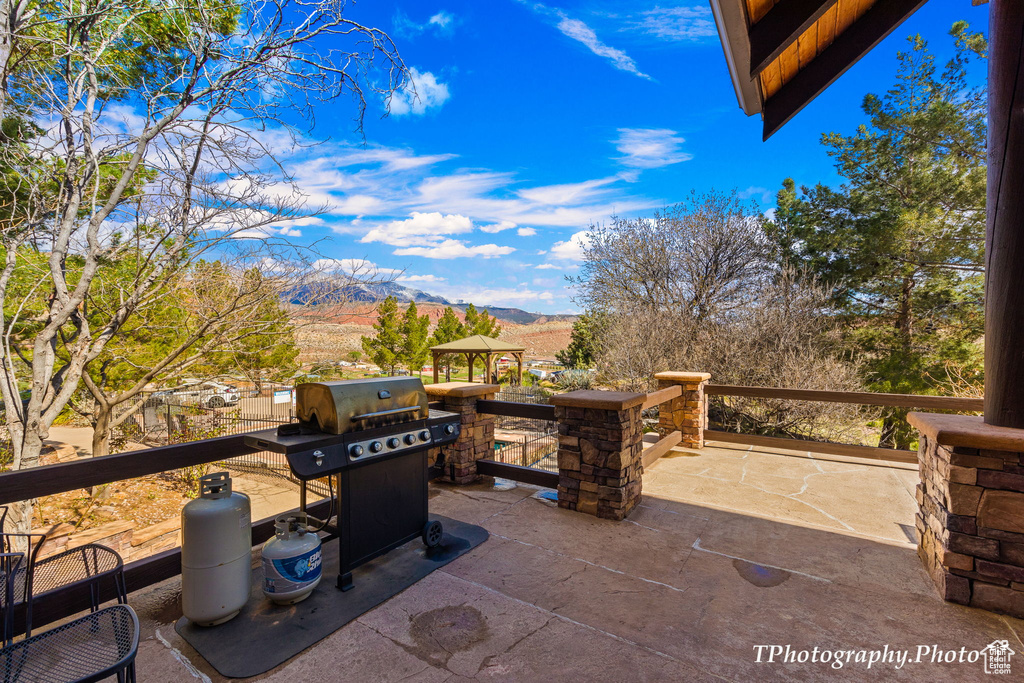 View of patio with a mountain view and area for grilling