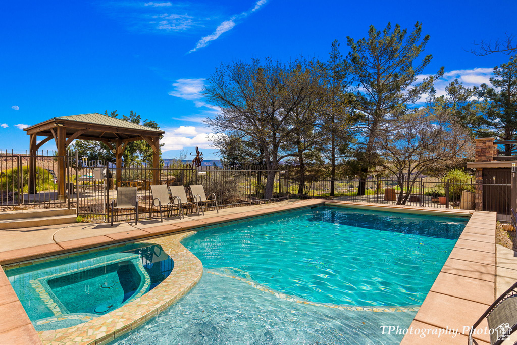 View of pool featuring a gazebo, a patio area, and an in ground hot tub